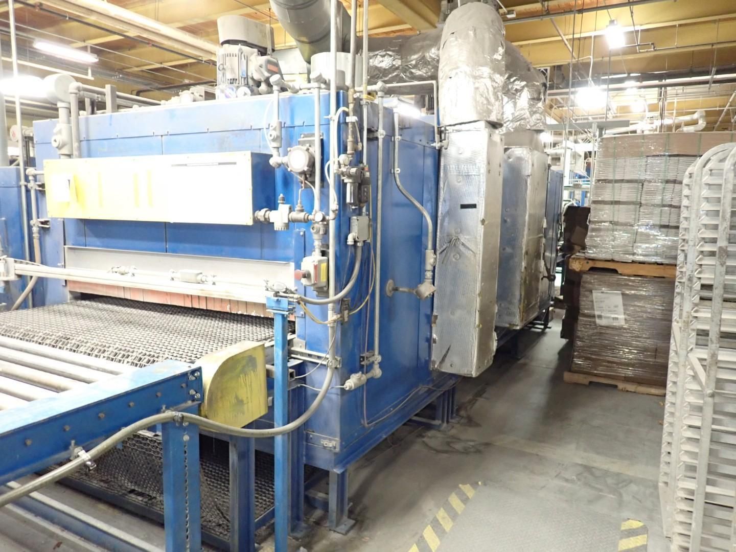 Industrial blue oven with conveyor belt, used for processing materials in a factory setting.