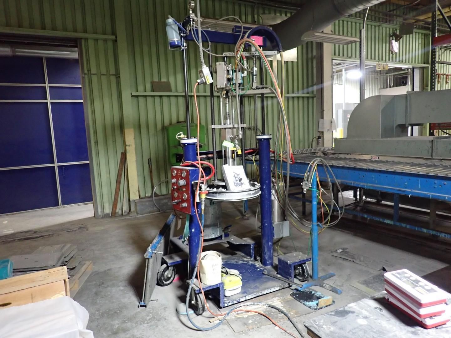 Blue industrial machine with wires and hoses in a factory.