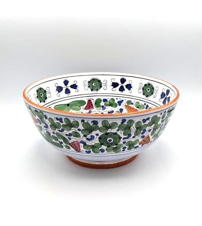 A decorative ceramic bowl featuring hand-painted green, blue, and red floral patterns against a white background.