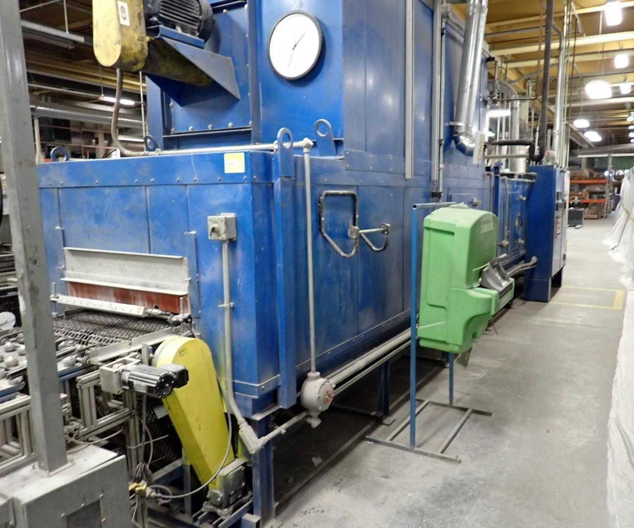 Blue industrial oven, with attached machinery, in a factory setting.