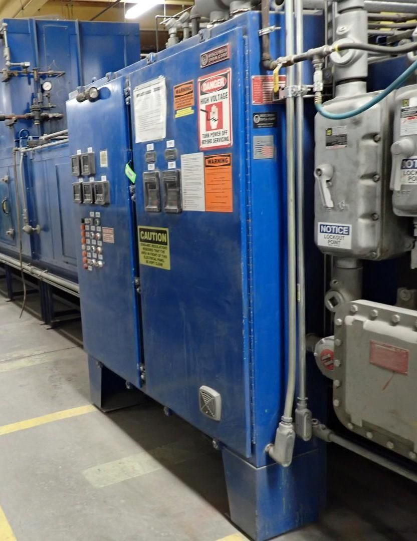 Blue industrial control panel with various gauges and warning labels.