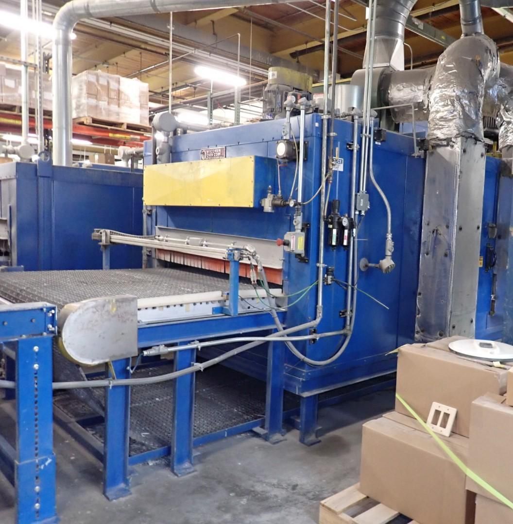 Blue industrial oven machine with a conveyor belt in a factory.