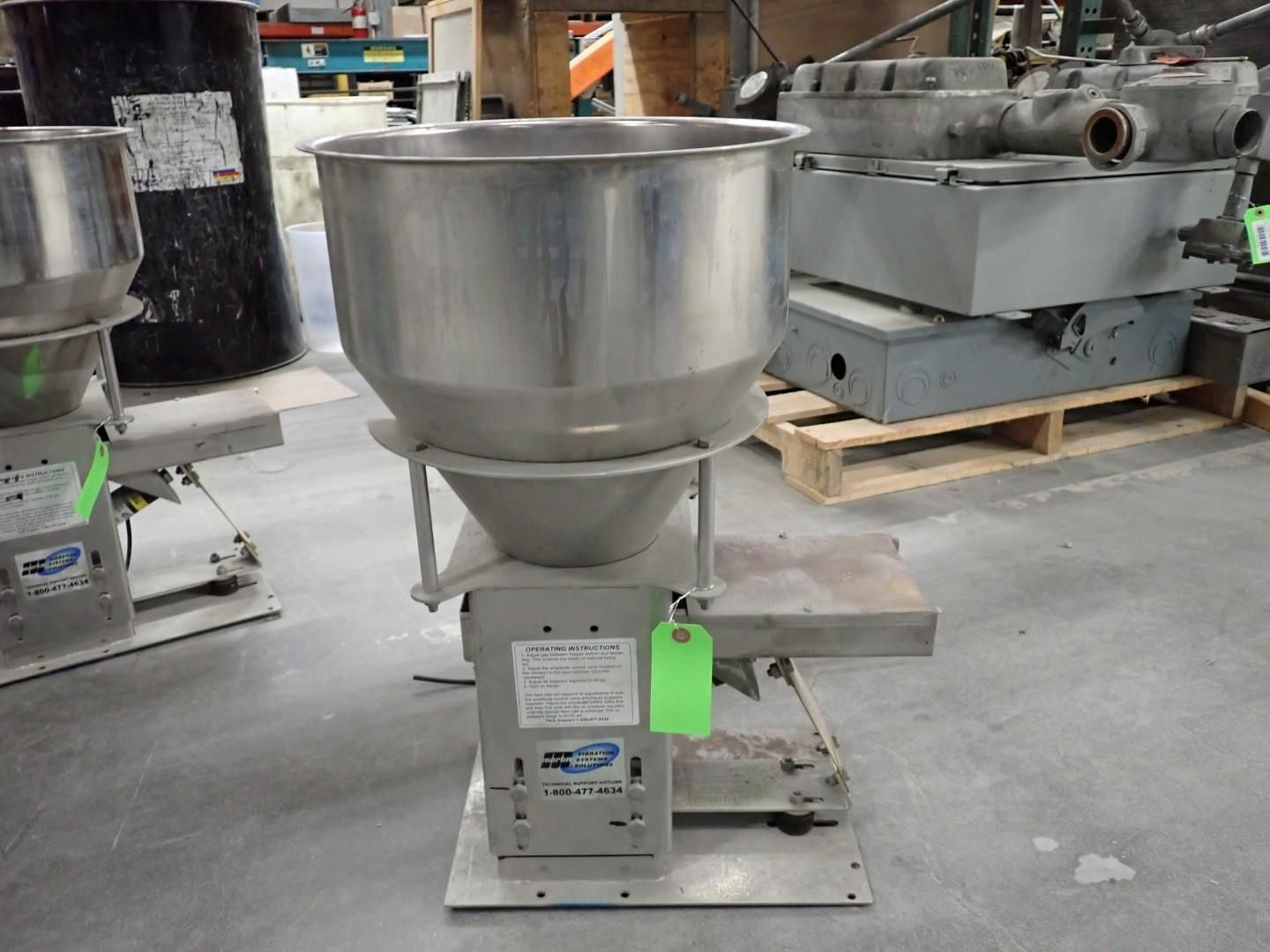 Stainless steel industrial hopper on a gray metal base with electrical components.