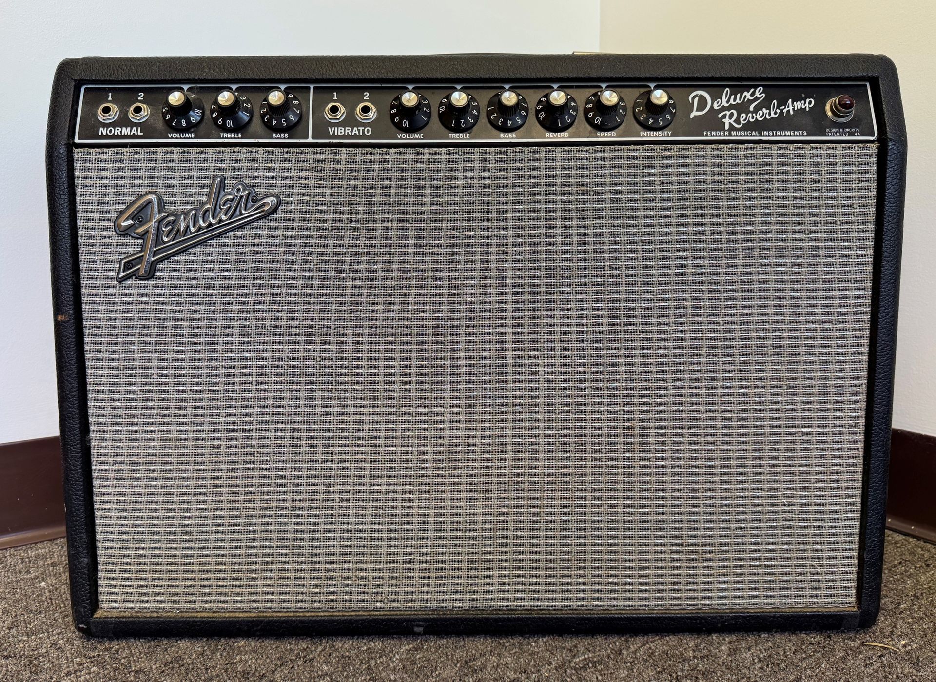 Black Fender guitar amplifier with control knobs on top and silver grille cloth.