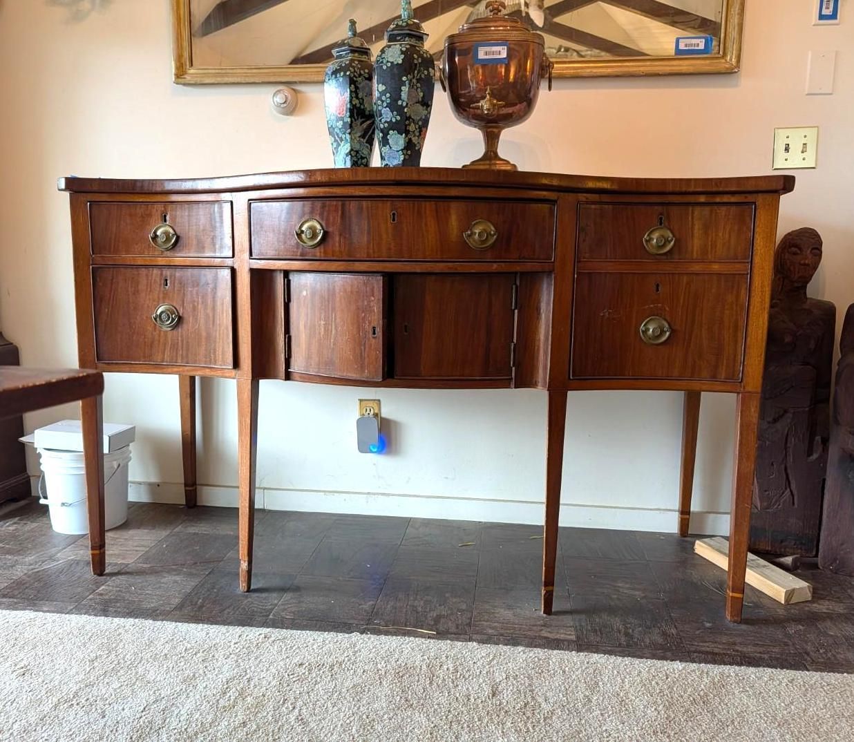A mahogany-toned sideboard with central cabinet doors and flanking drawers.