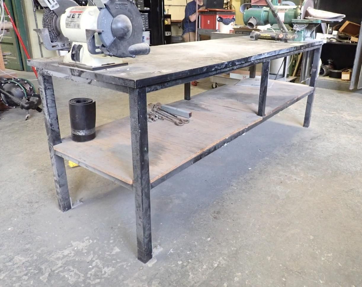 Workshop workbench with a grinder, shelf, and tools.