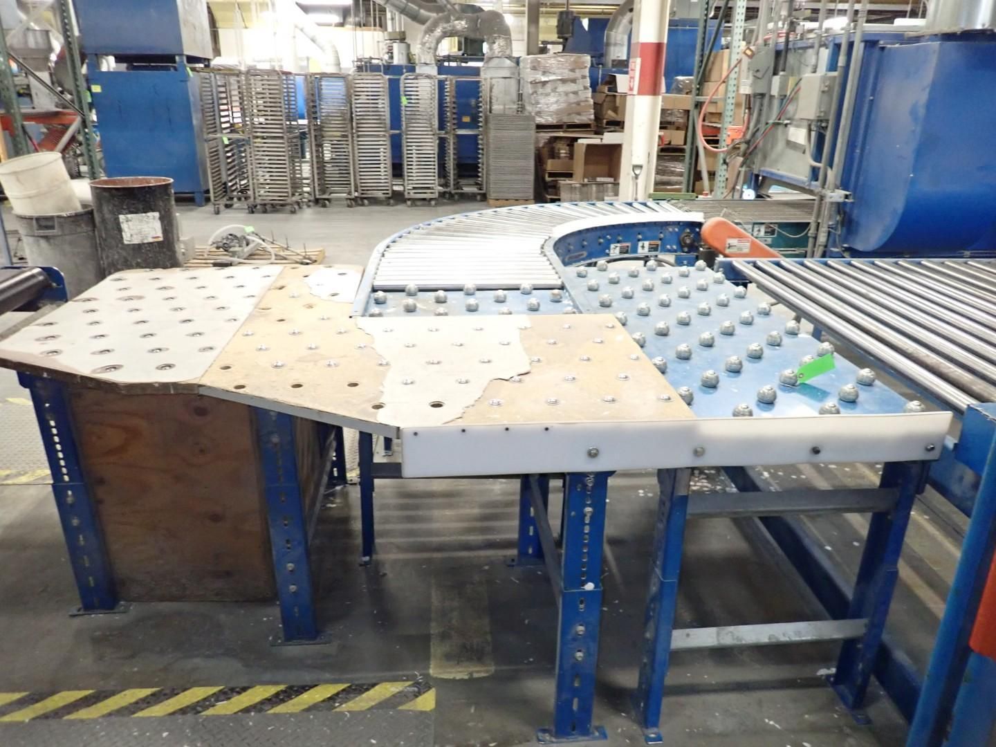 A work table with a conveyor belt in a factory setting. The table has a wood and metal construction.