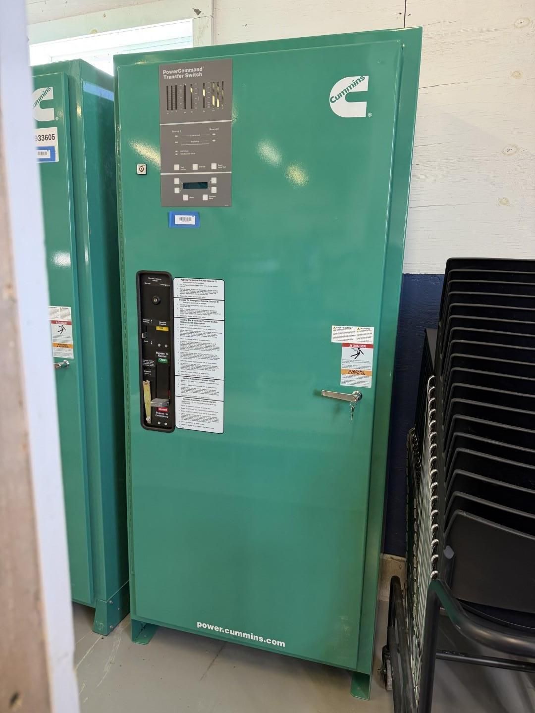 Green Cummins electrical cabinet in a room.