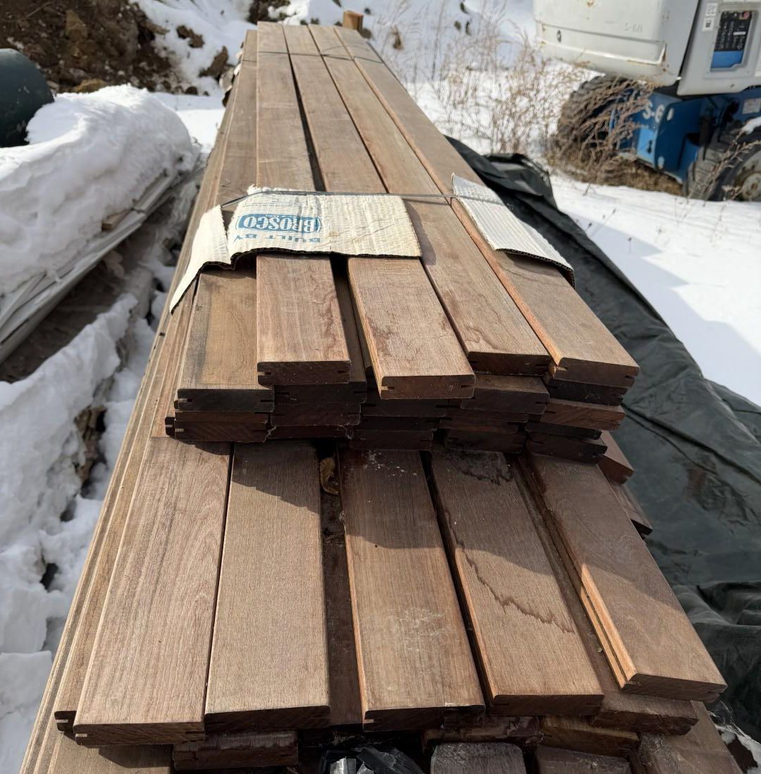 Bundle of dark wood planks, possibly decking.