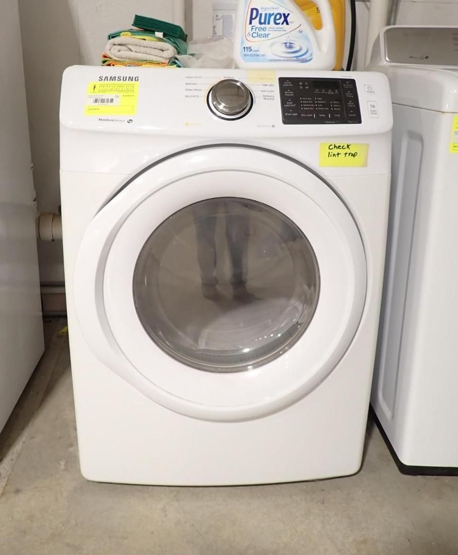 A white Samsung front-load dryer in a laundry room.