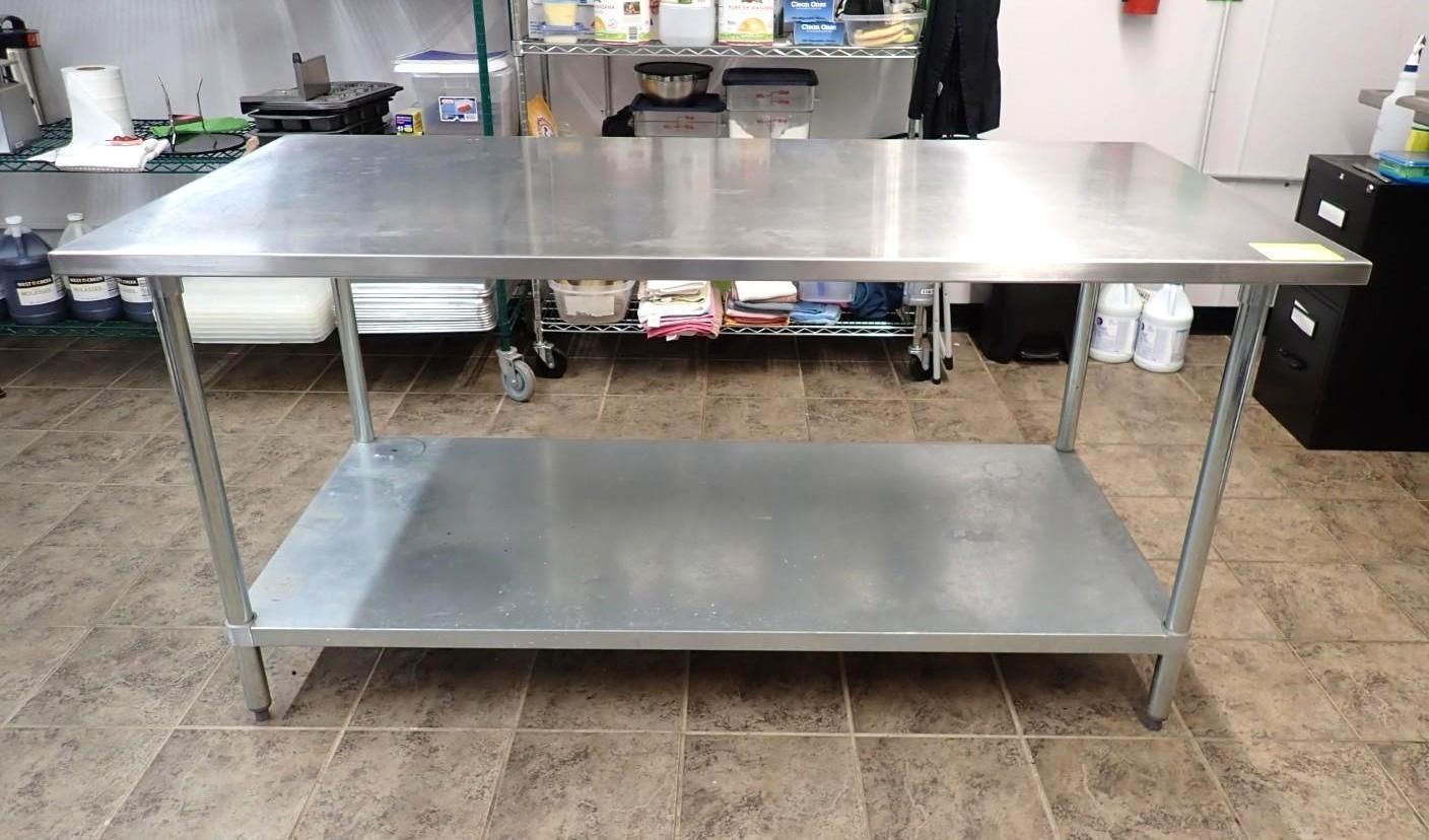A stainless steel work table with a lower shelf, positioned in an indoor kitchen or storage area with tiled flooring.