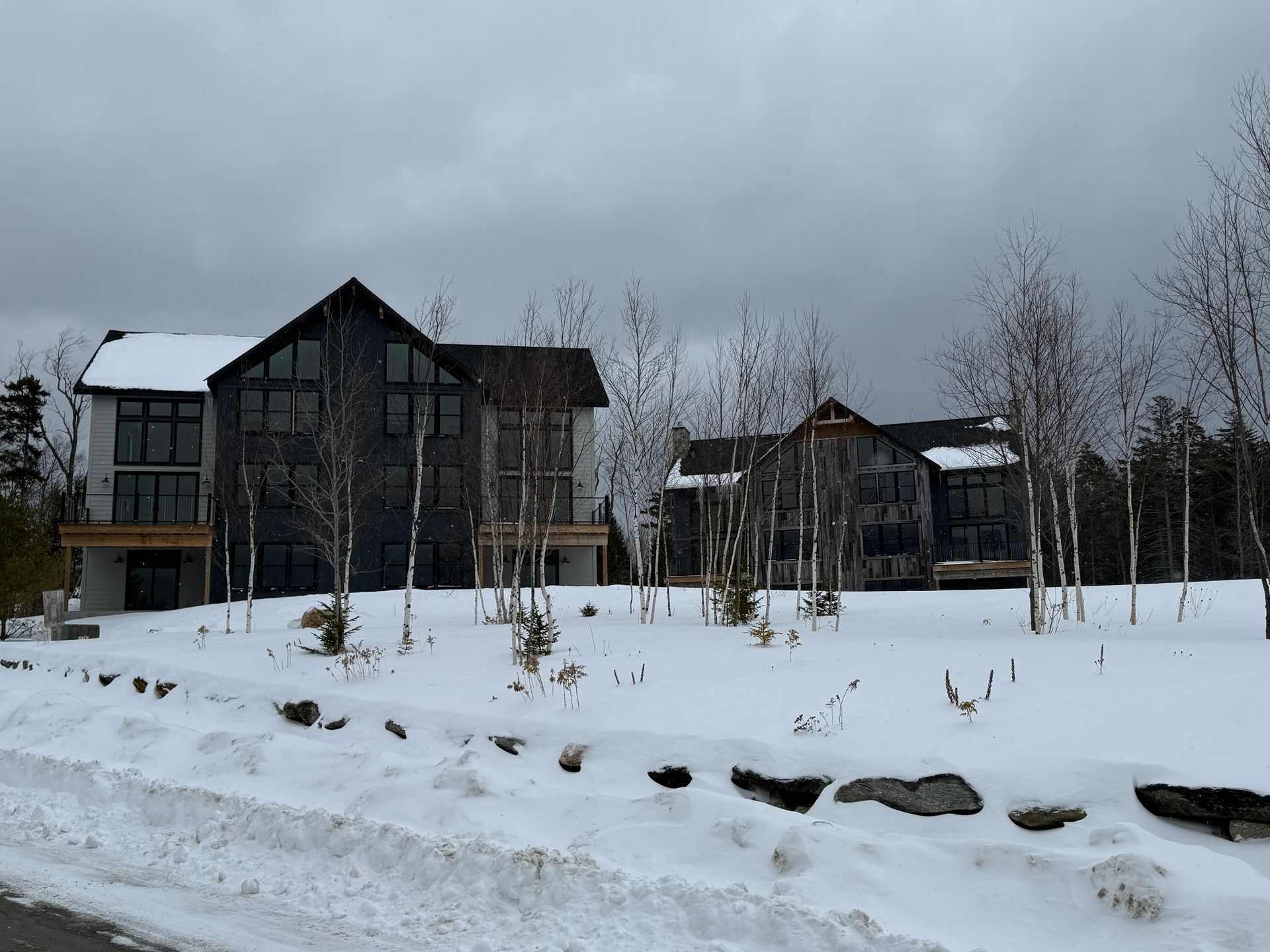 Snow-covered landscape with modern multi-story buildings; overcast sky. Boulder Ridge Foreclosure Property.