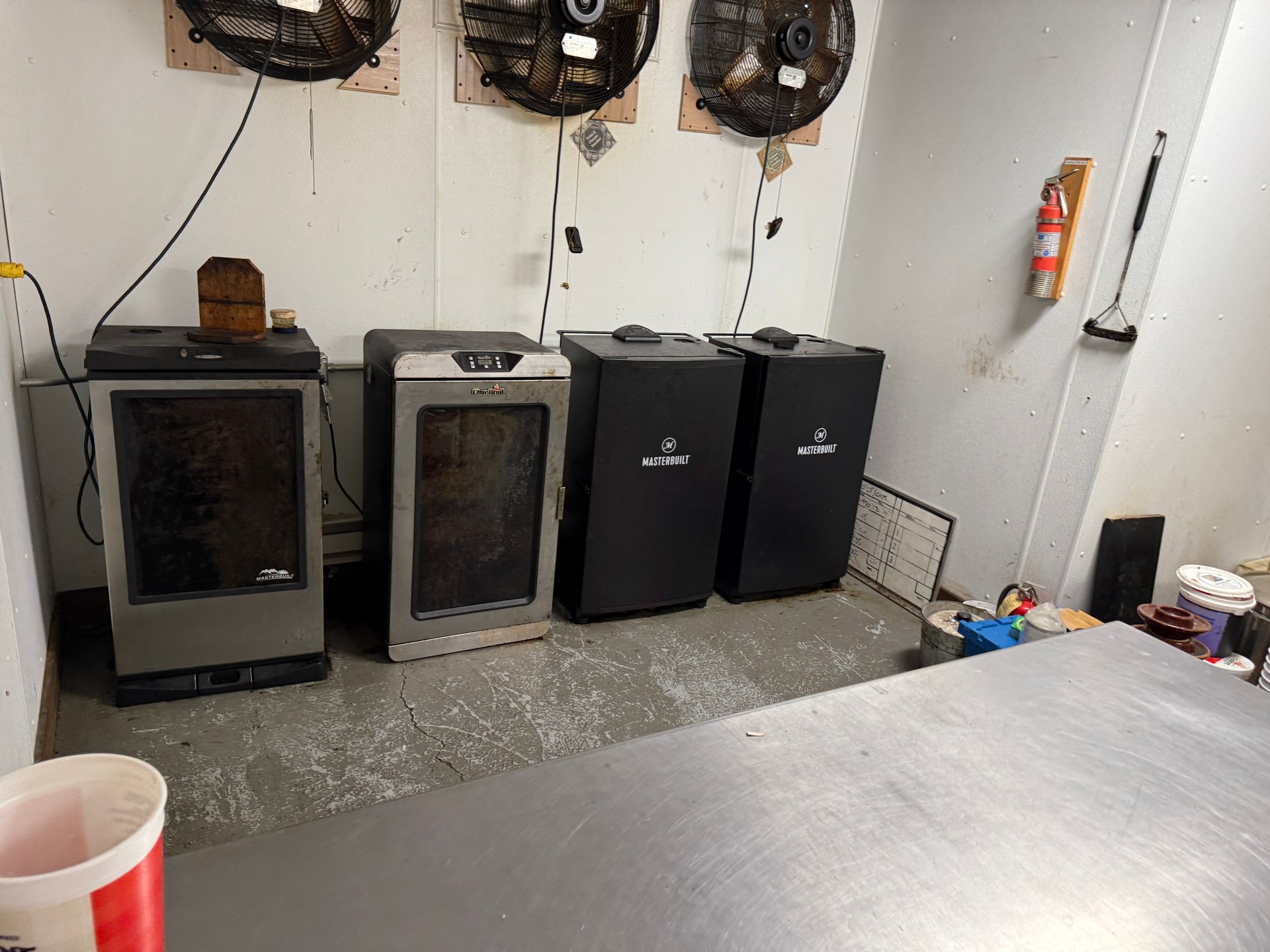 Three black cabinet-style units and a gray unit against a wall