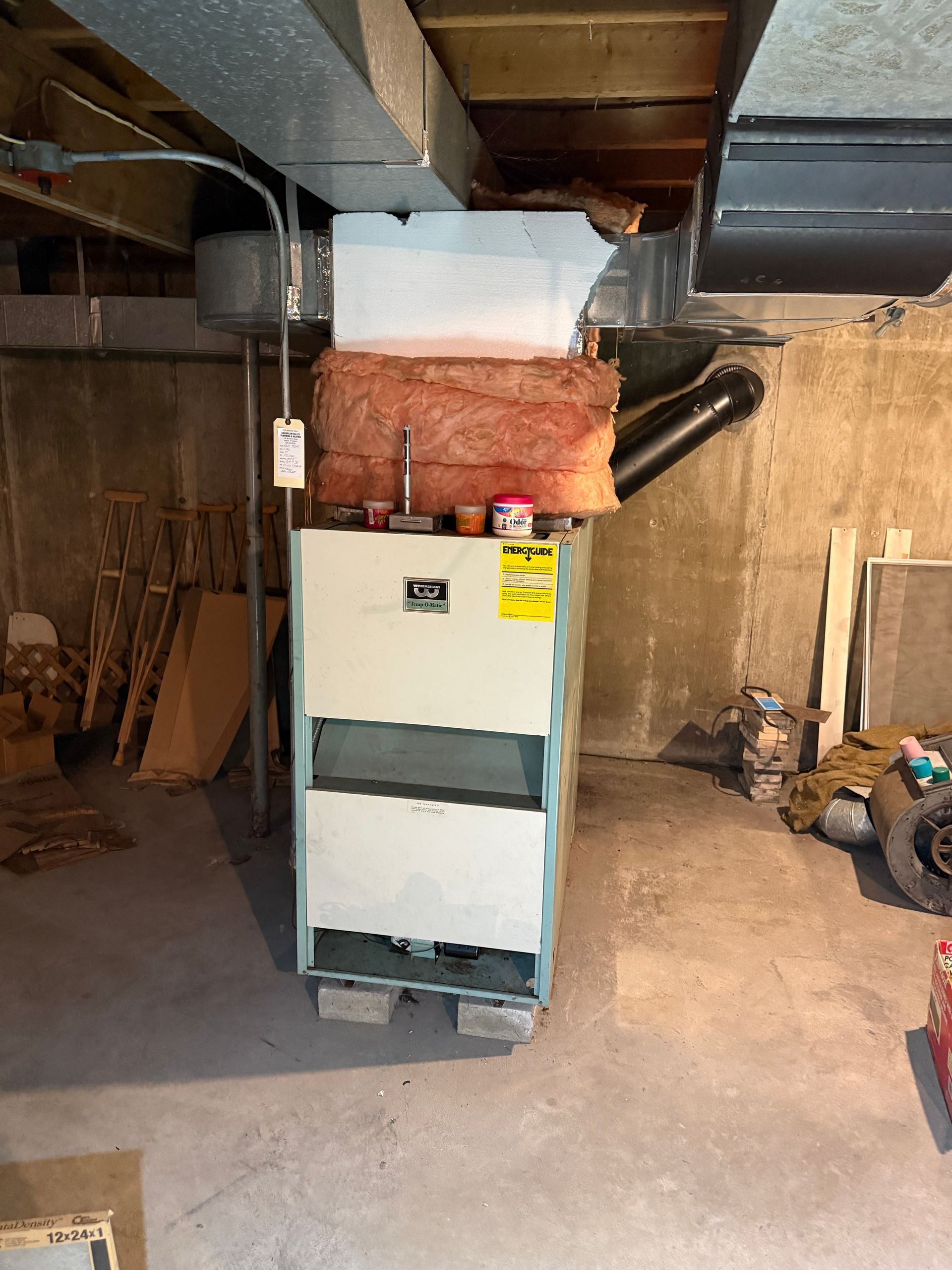 Furnace in a basement setting, with ductwork and insulation visible.