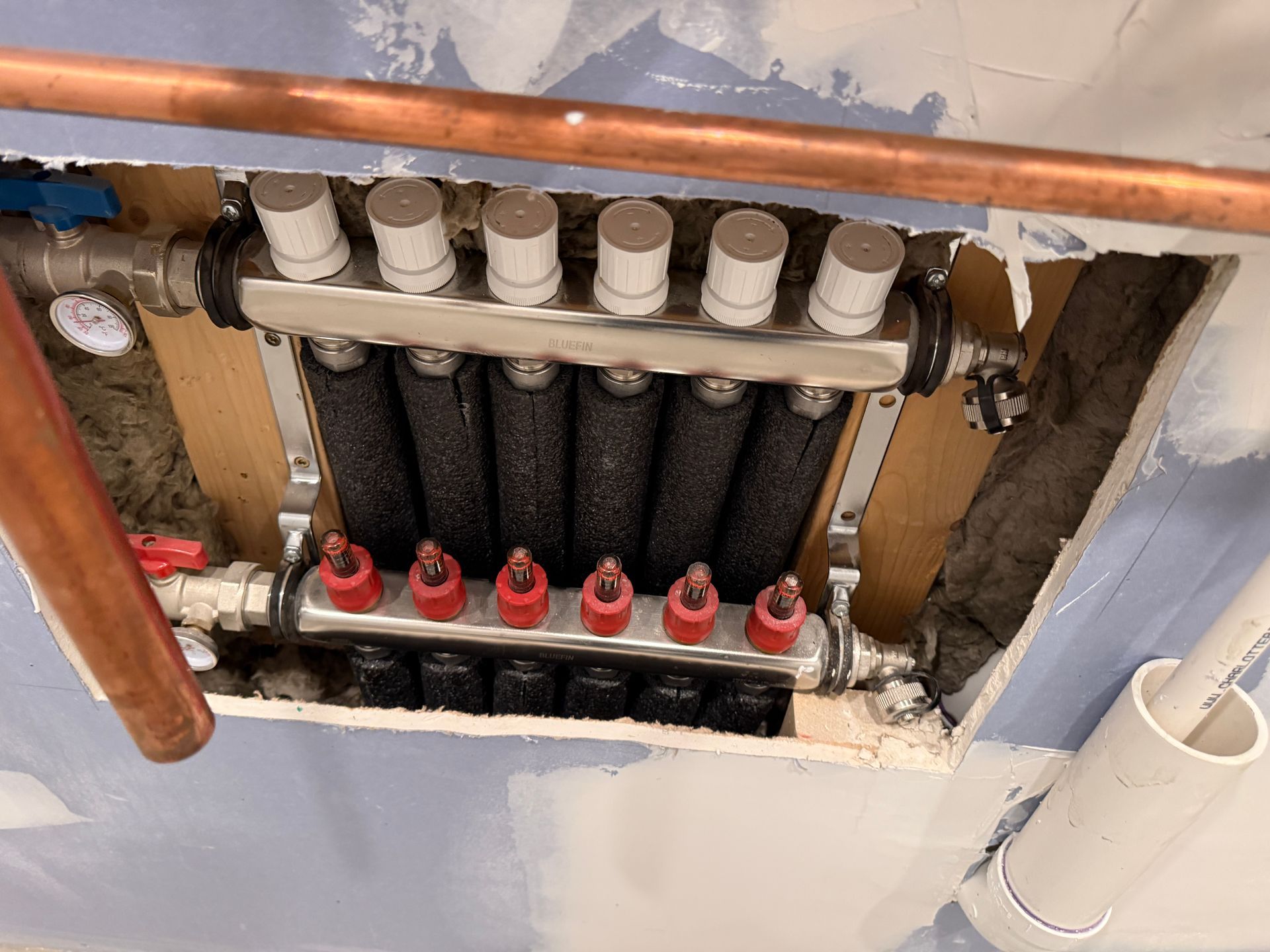 Radiant heating manifold installed in an unfinished wall.