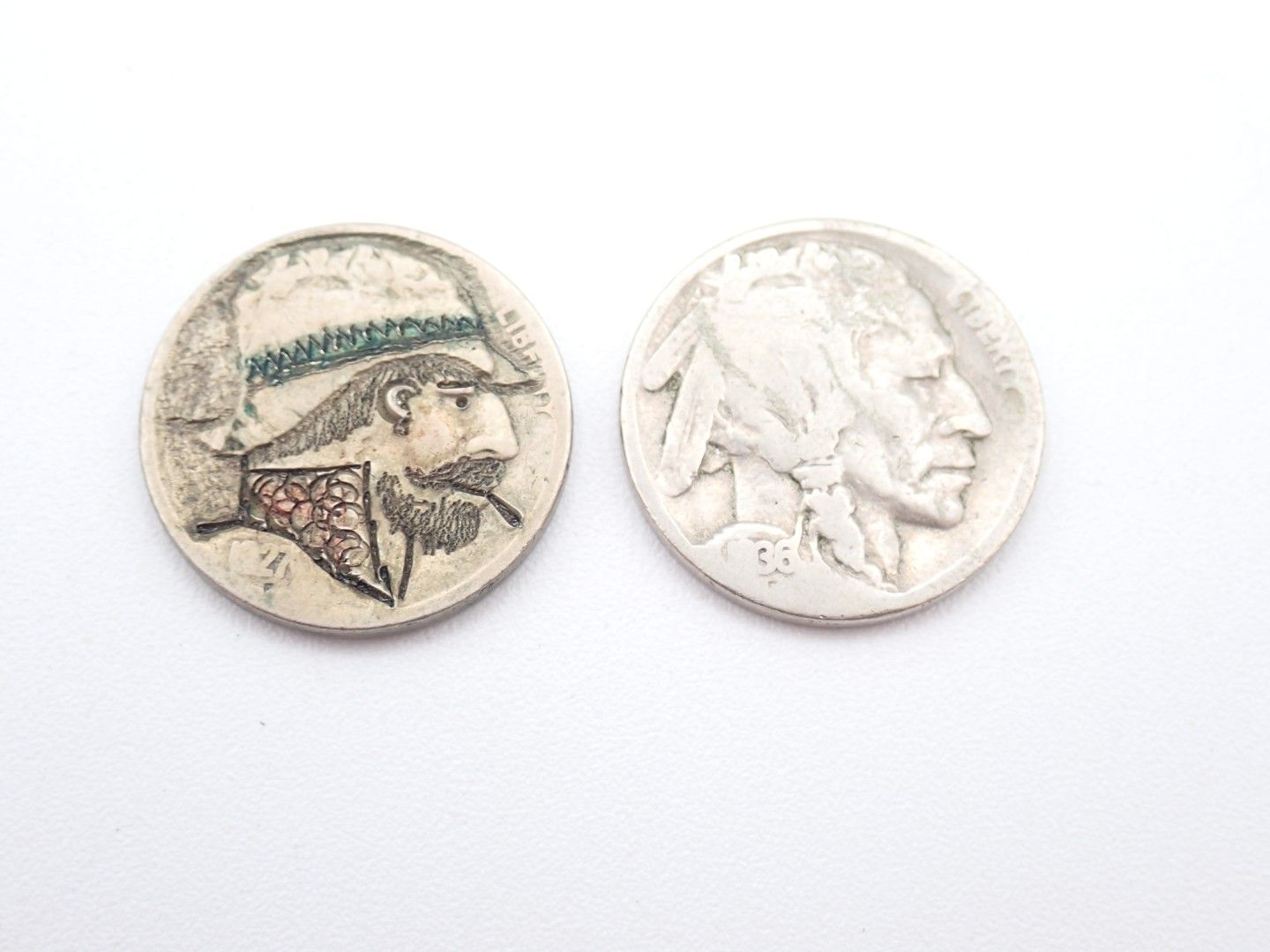 Two small vintage coins, one with a profile portrait in color, one silver with a profile relief