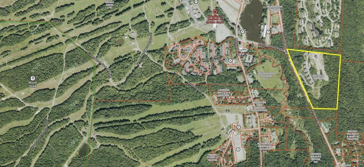 Satellite view of a resort area with a yellow outline highlighting a specific parking and wooded property section.