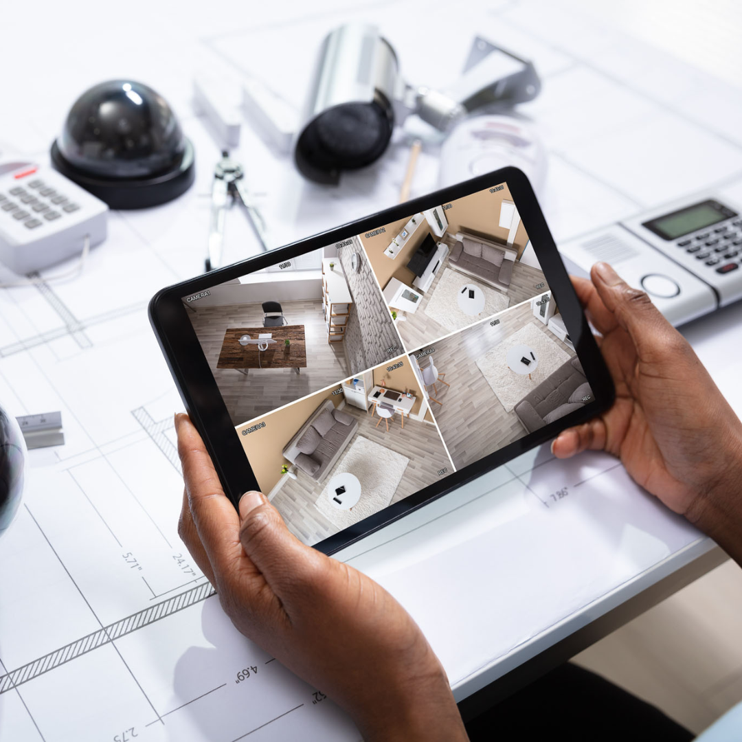 Une personne tenant une tablette affichant le flux vidéo d'une caméra de sécurité