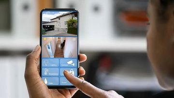 Personne utilisant un smartphone, visualisant plusieurs flux de caméras de sécurité
