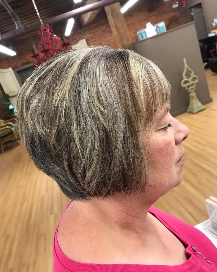 A woman with short gray hair is sitting in a salon.
