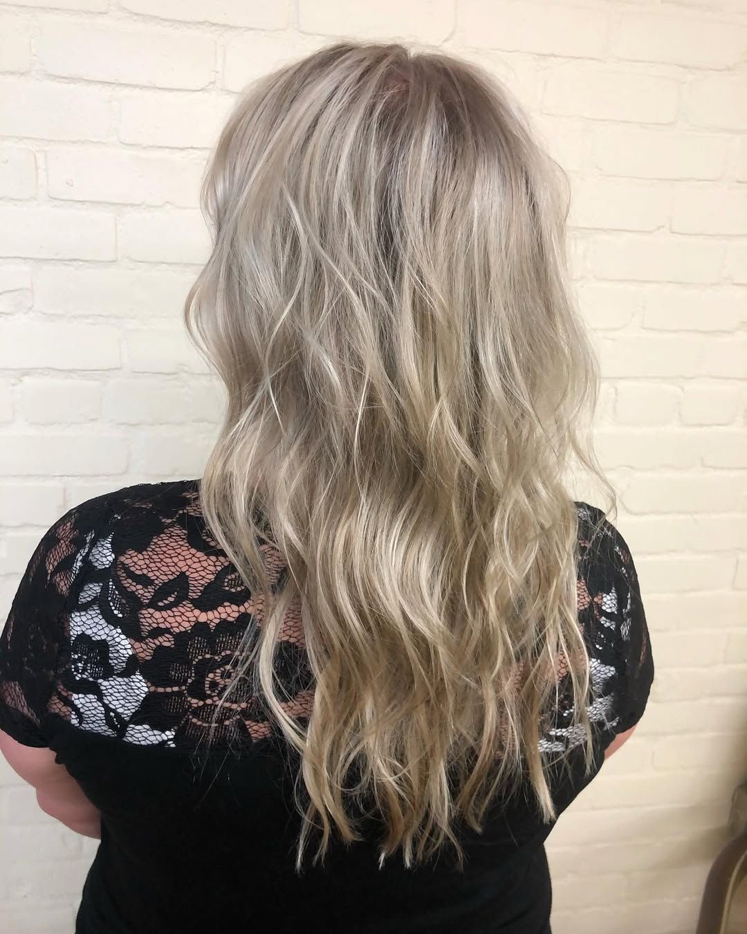 A woman with long blonde hair is wearing a black shirt