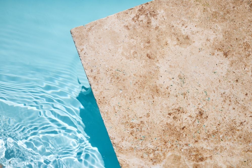 A tile is floating in a pool of water.