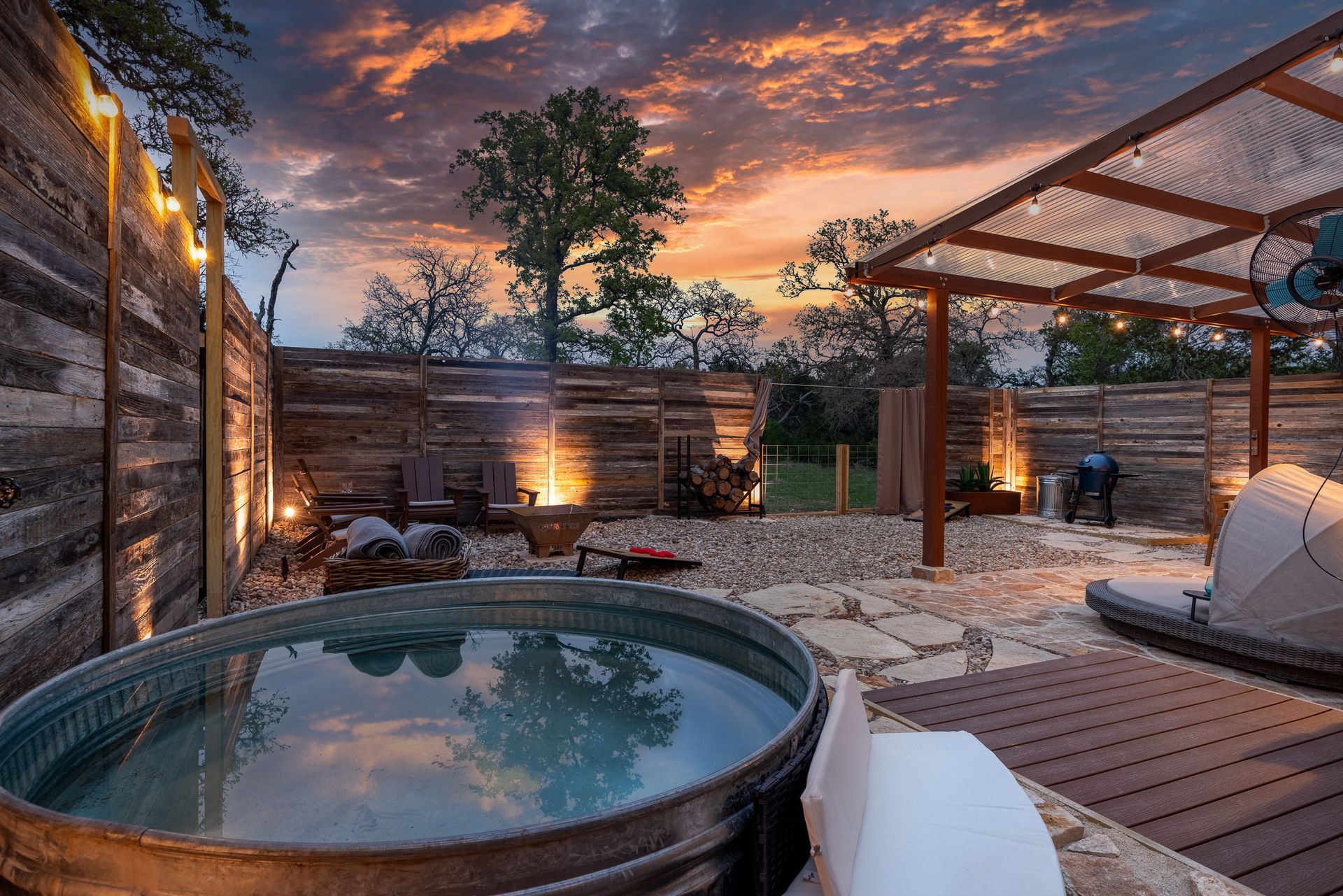 Stock-tank plunge pool and pergola in Quiroga cabin's private spa yard at sunset