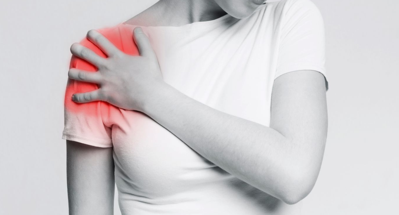 Die Person hält sich schmerzverzerrt die rechte Schulter; die rote Markierung zeigt die Stelle des Schmerzes an.