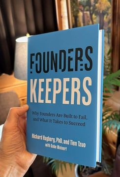 A person is holding a book titled founders keepers