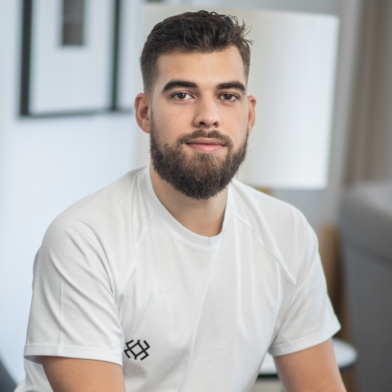 A man with a beard is wearing a white shirt