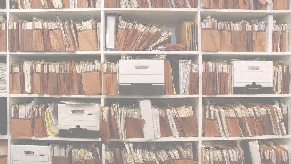 A shelf filled with lots of folders and boxes.