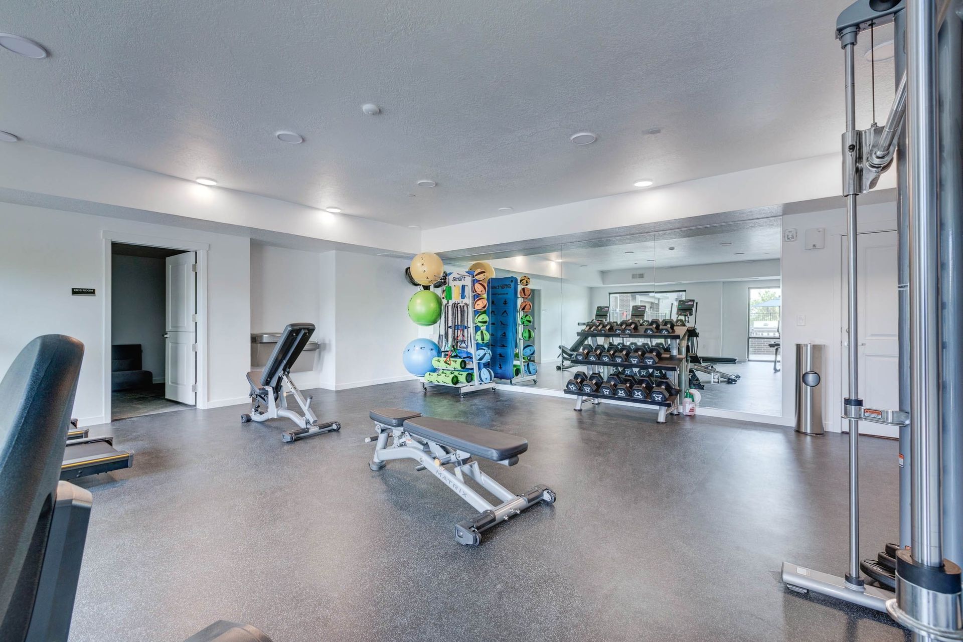 A gym with a lot of equipment and a large mirror 7th West at Midtown.