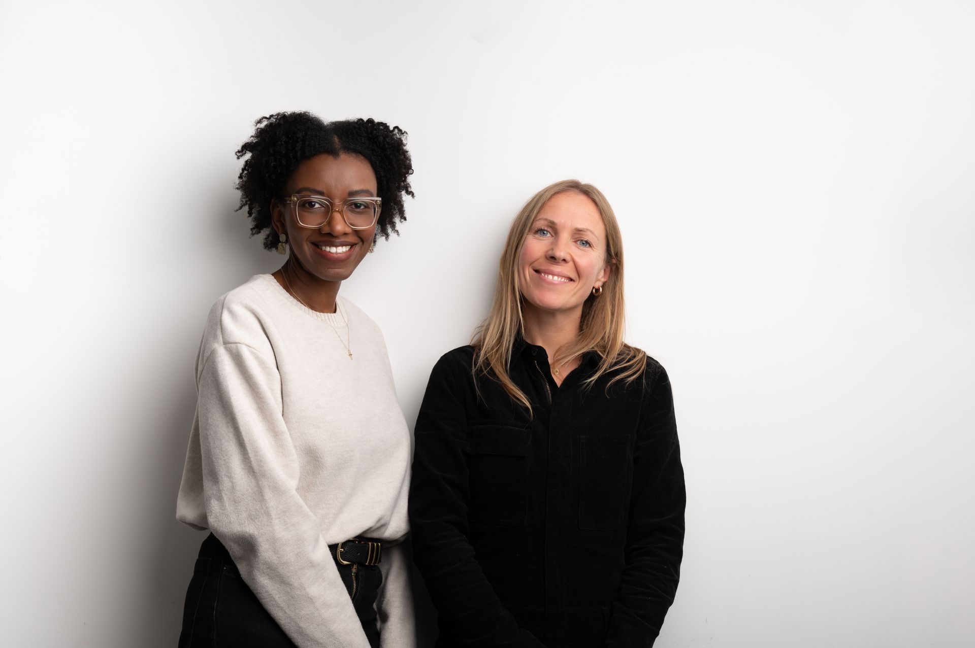 2 smiling women on white background