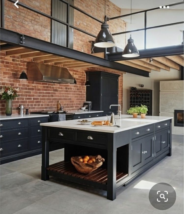 Modern kitchen with gray cabinets, wooden island with stools, and stainless steel appliances.