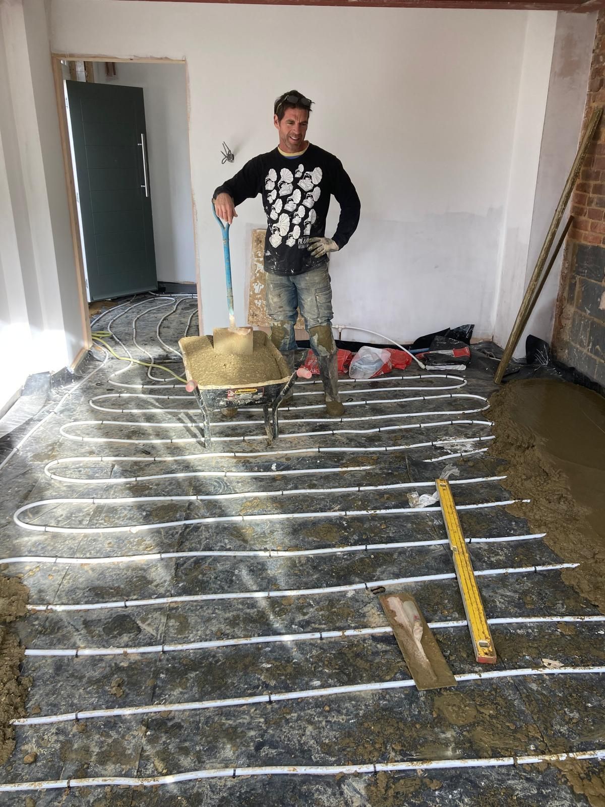 House with green roof and solar panels in a residential area.