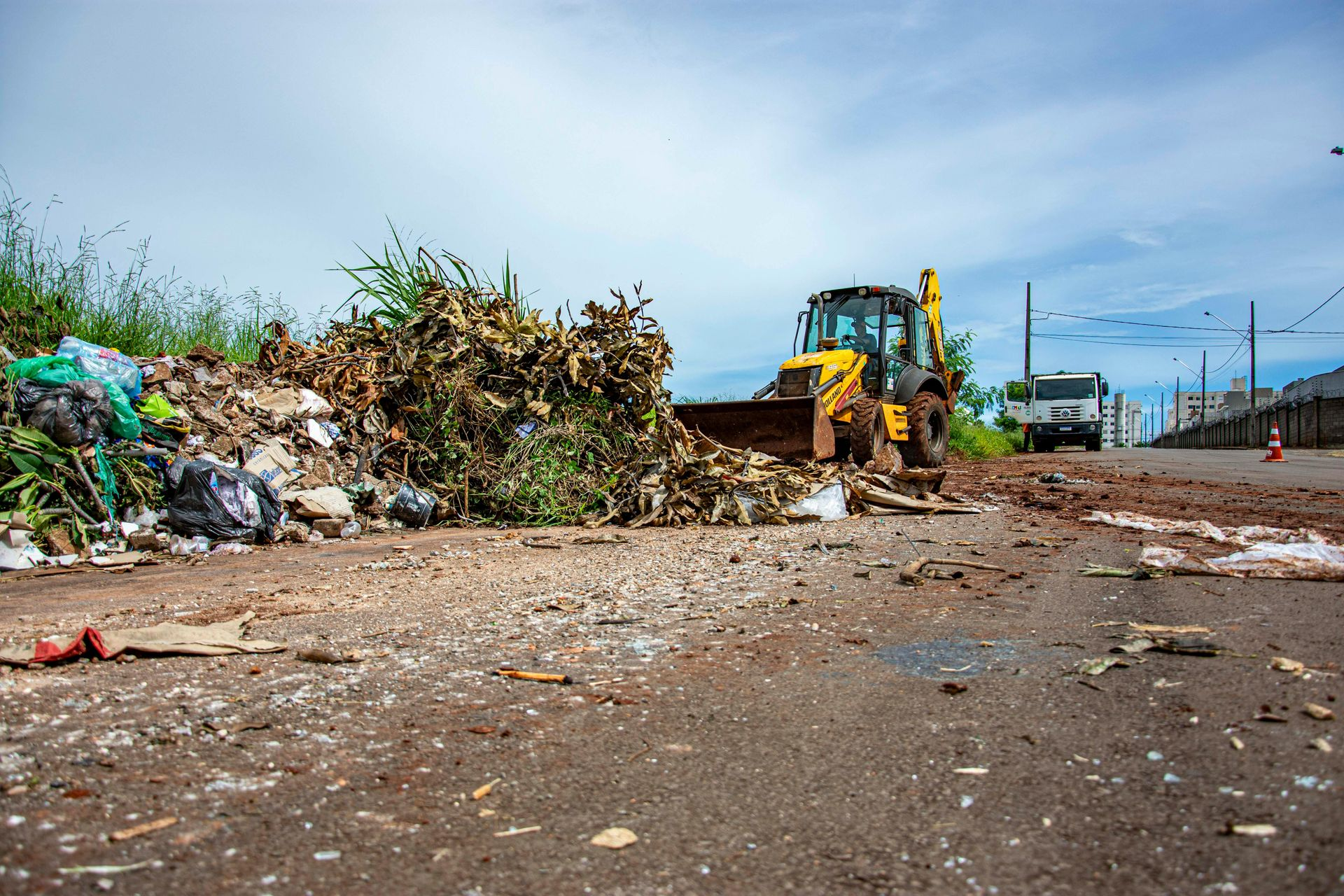 A forklift cleaning outdoor lot from outdoor waste