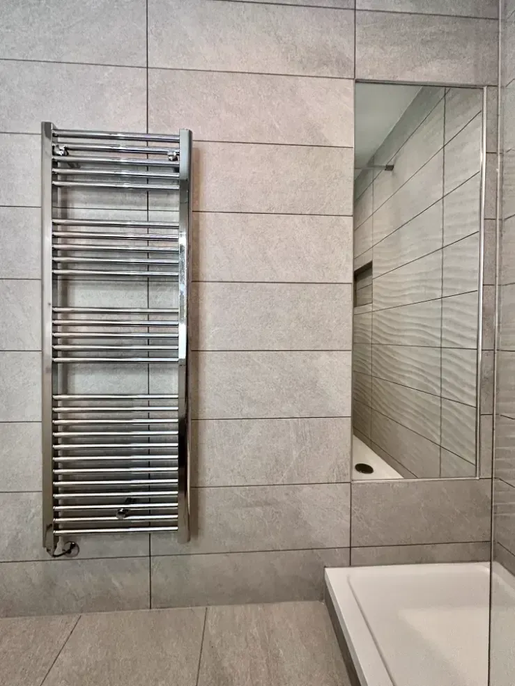 A bathroom with a towel rack and a mirror
