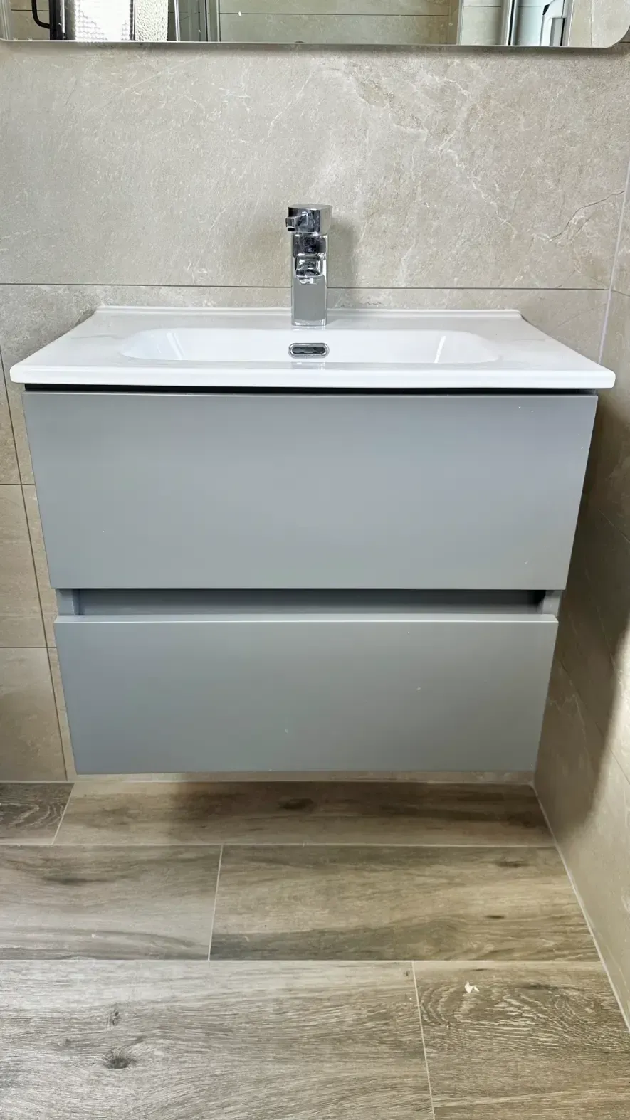 A bathroom vanity with a sink and a mirror.