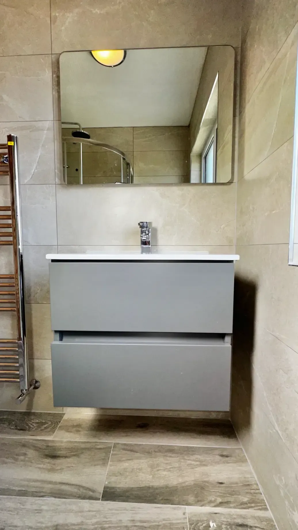 A bathroom with a sink , mirror and towel rack.