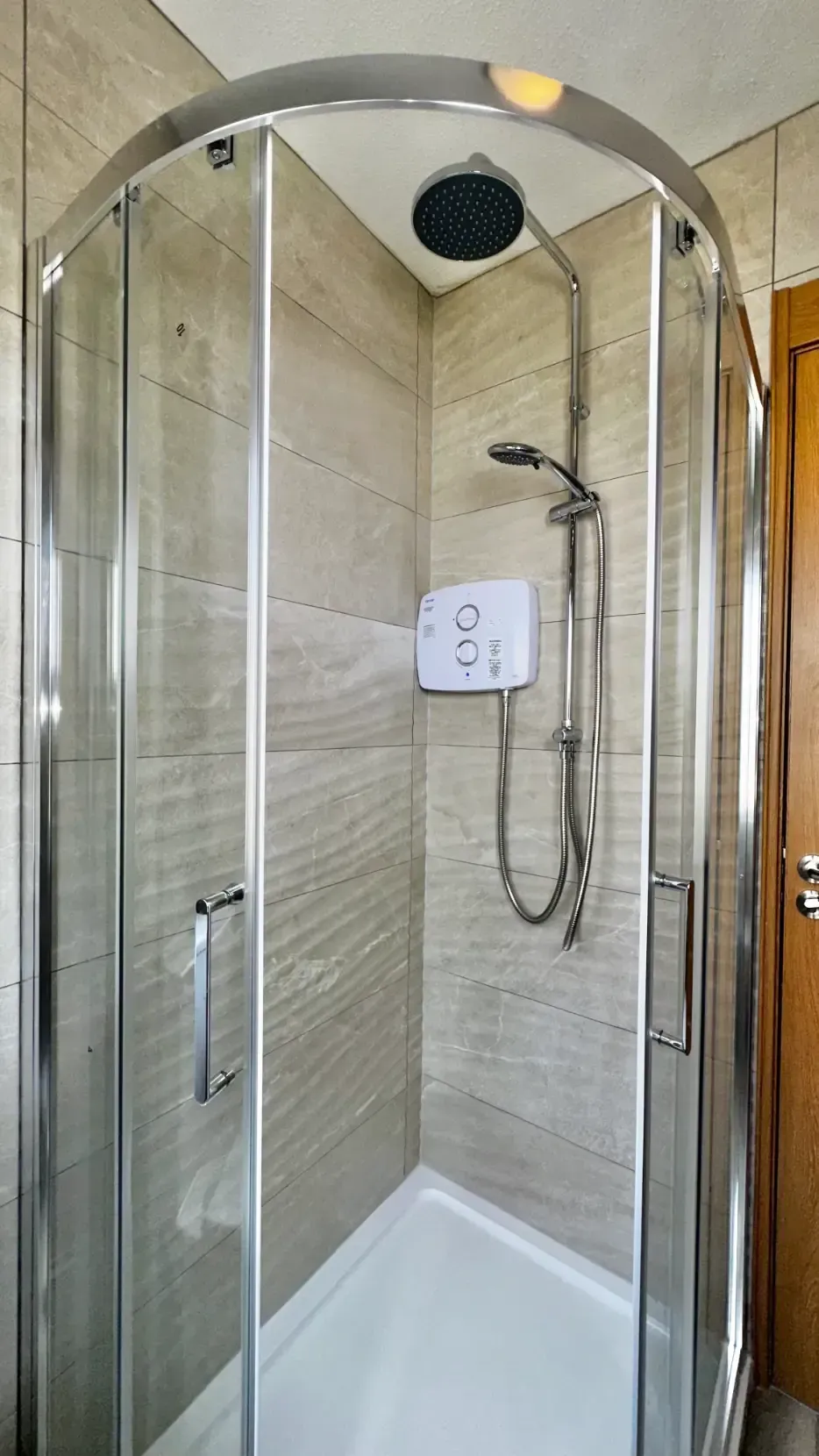A bathroom with a shower stall and a shower head.