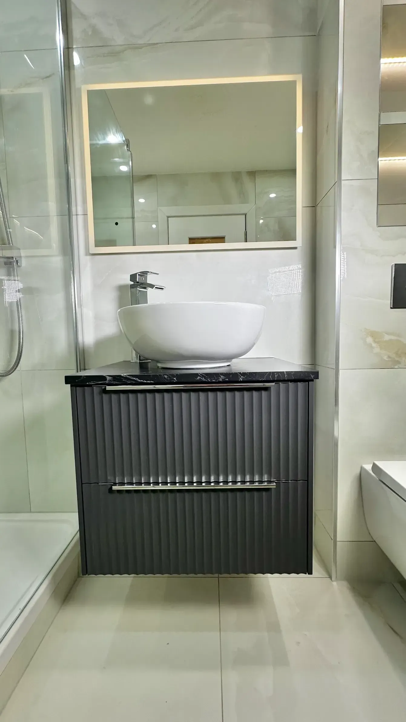 A bathroom with a sink , mirror and toilet.