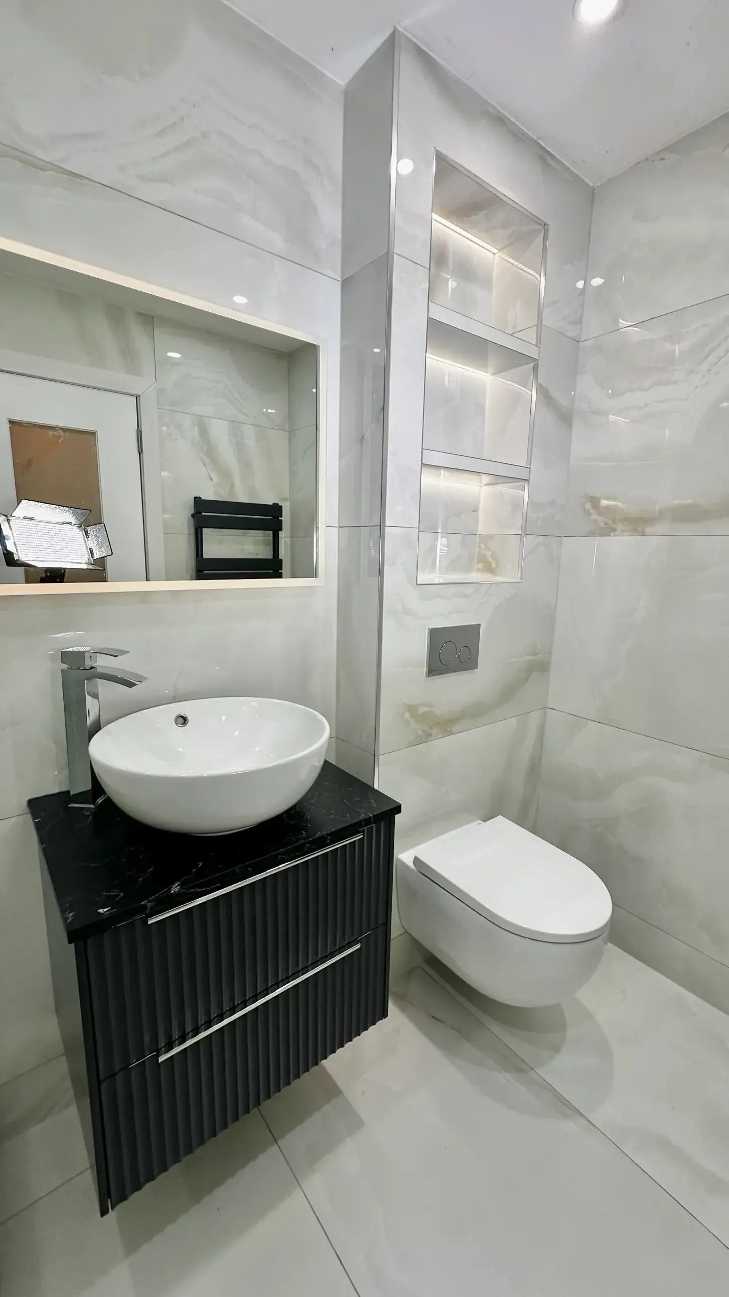 A bathroom with a sink , toilet and mirror.