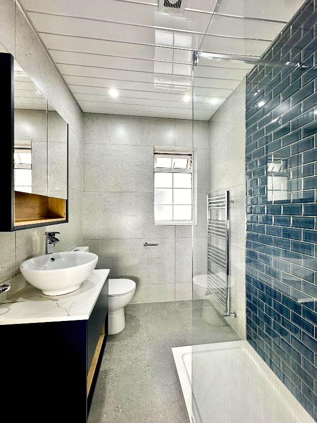 A bathroom with a sink , toilet , shower and bathtub.