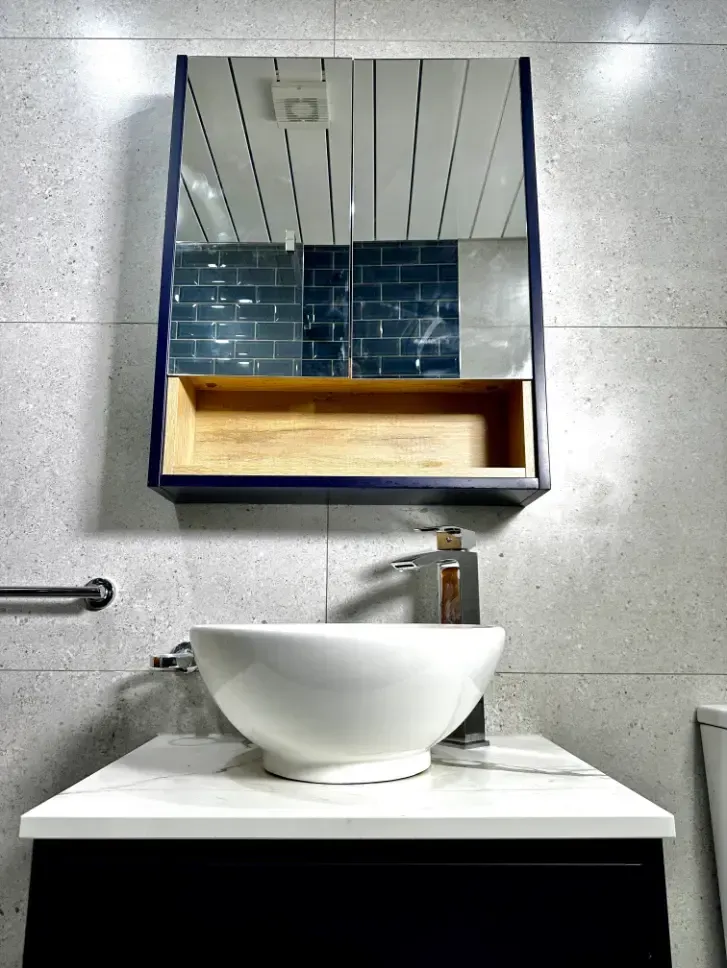 A bathroom with a sink and a mirror on the wall