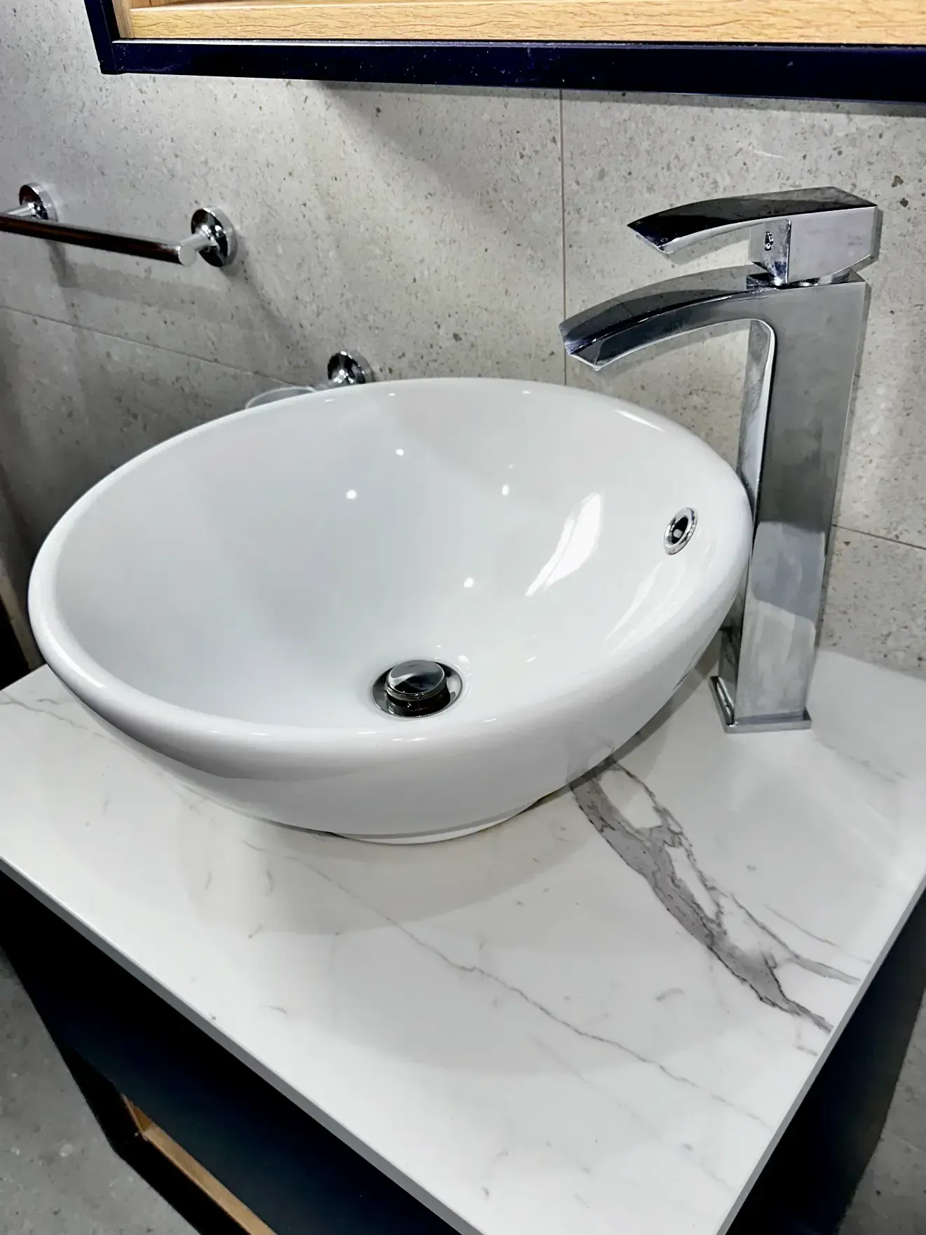A white sink is sitting on top of a white counter top in a bathroom.