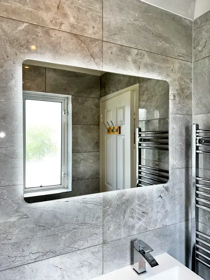 A bathroom with a large mirror and a sink