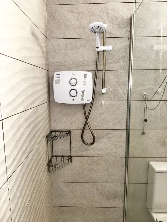 A bathroom with a shower head and a toilet.