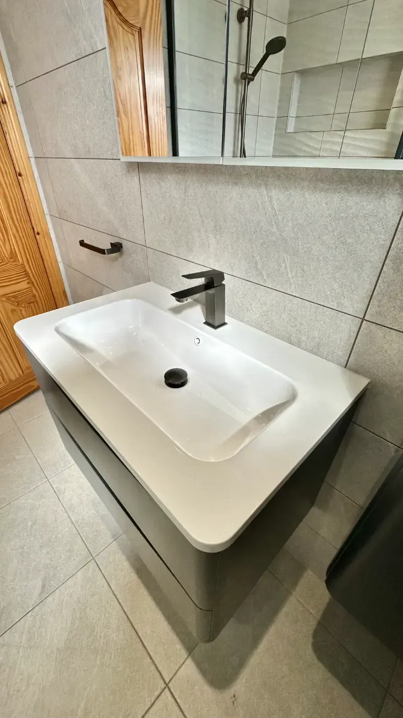 A bathroom sink with a faucet and a mirror.