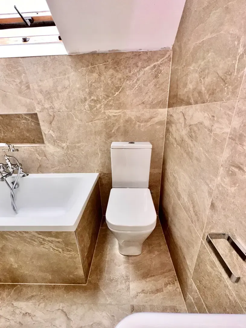 A bathroom with a toilet , bathtub and shower.