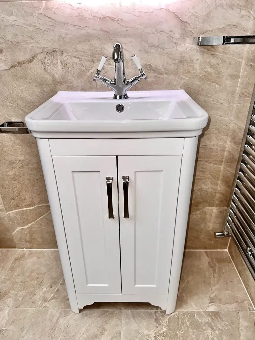 A bathroom sink with a white cabinet and a faucet.